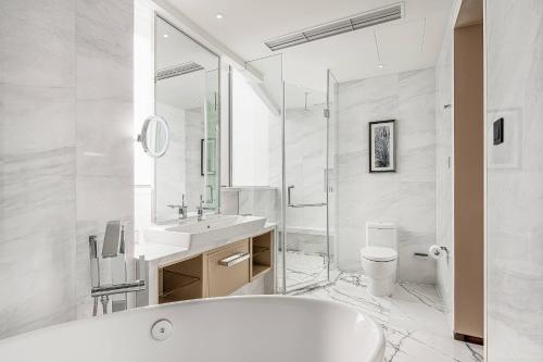 a white bathroom with a tub and a sink at Renaissance Shanghai Caohejing Hotel in Shanghai