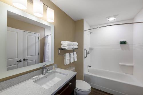 a bathroom with a sink and a toilet and a mirror at TownePlace Suites by Marriott St. Louis Edwardsville, IL in Edwardsville