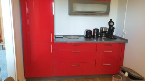 a red cabinet in a corner of a room at EXCLUSIVES TOP-Apartment in traumhafter Aussichtslage WLAN kostenfrei in Schöfweg