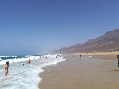 a group of people playing in the water on a beach at A los Soles de Fuerteventura in Costa de Antigua