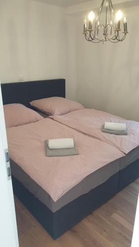 1 dormitorio con 1 cama con 2 toallas en EXCLUSIVES TOP-Apartment in traumhafter Aussichtslage WLAN kostenfrei, en Schöfweg