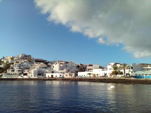 un grupo de edificios blancos junto a una masa de agua en A los Soles de Fuerteventura, en Costa de Antigua
