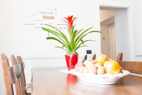 un bol de fruits sur une table avec une plante dans l'établissement B&B Peruzzi Rooms, à Civitavecchia