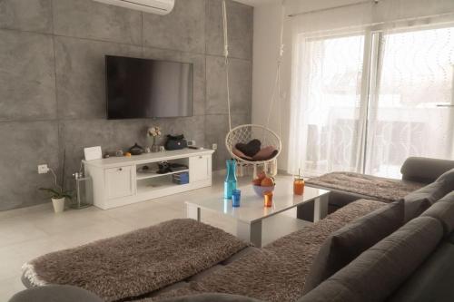 a living room with a couch and a tv at Apartman Stella in Pula