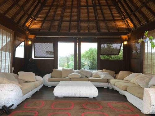 una gran sala de estar con sofás blancos y ventanas. en Villa Oasis 10 pers, piscina, BBQ, 10 min playa, en El Tosalet