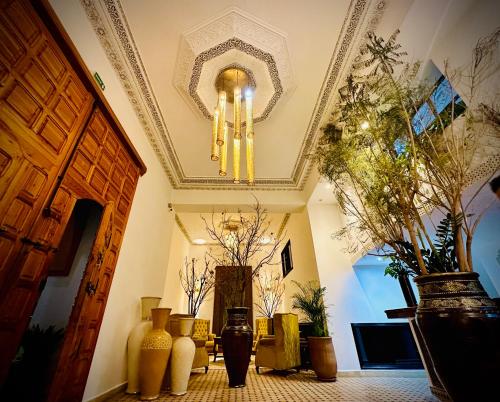 Cette chambre dispose de vases et d'un plafond orné d'un lustre. dans l'établissement Riad Soir De Marrakech, à Marrakech