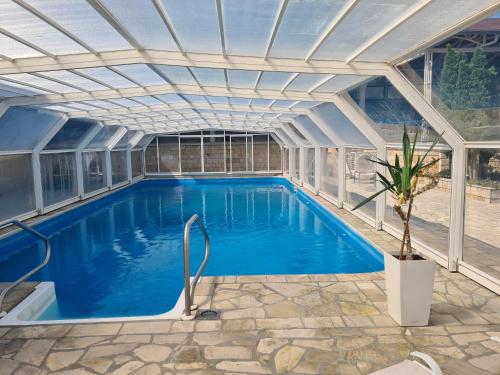 an indoor swimming pool with an expandable roof at Sunny Hill Apartments & Aqua Park in Vrnjačka Banja