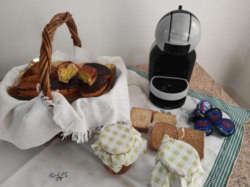 een tafel met een broodmand en een koffiezetapparaat bij La dimora dei nonni in Tuglie