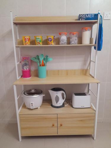 Afna Home stay في كوالا ليبيس: رف خشبي عليه ادوات مطبخ متنوعة