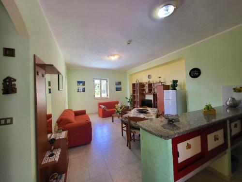 cocina y sala de estar con sofá rojo en Villa Selene "Jole", en Ioppolo