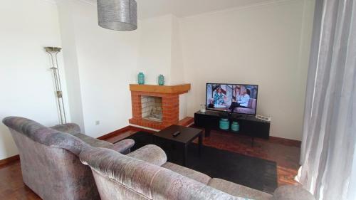 - un salon avec un canapé et une cheminée dans l'établissement Apartamento Solzende, à Esposende