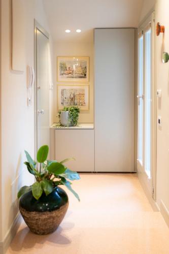 a hallway with a vase with a plant in it at Palazzo Scappi Gardi Luxury Apartments in Bologna