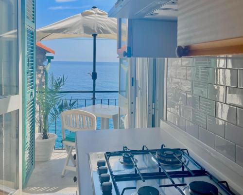 uma cozinha com fogão e vista para o oceano em Families or Groups 3 Terrazzi Apartment on Sea em Vernazza