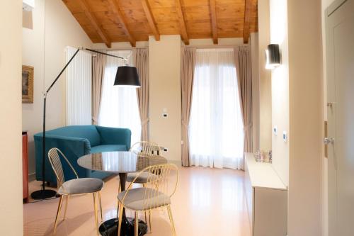 a living room with a table and chairs and a couch at Palazzo Scappi Gardi Luxury Apartments in Bologna