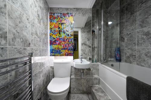a bathroom with a toilet and a sink and a tub at Albert's Rest in Ramsgate