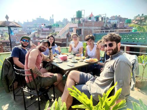 a group of people sitting around a table on a balcony at Hotel Bhaktapur Inn in Bhaktapur