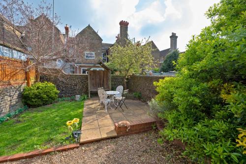 a garden with a table and chairs on a wooden deck at Albert's Rest in Ramsgate