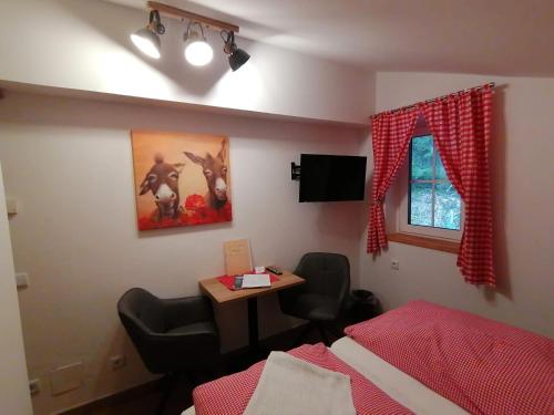 a bedroom with a bed and a table and a window at Haus Bergliebe in Filzmoos