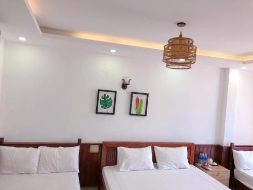 a bedroom with two beds and a chandelier at VIỆT Hostel in Hue