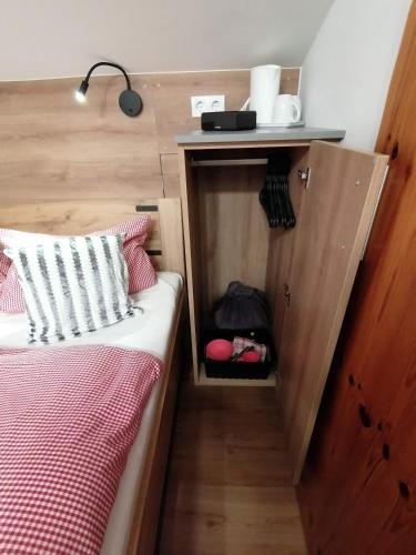 a small bedroom with a bed and a wooden wall at Haus Bergliebe in Filzmoos