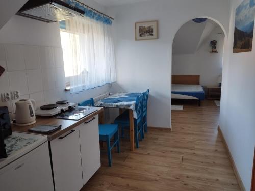 a kitchen with blue chairs and a table in a room at Jaskółka in Lądek-Zdrój