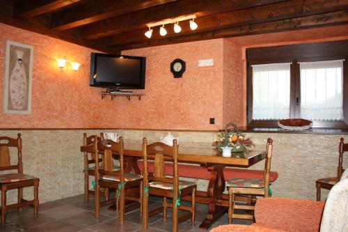 a dining room with a table and a tv on the wall at La Cabaña in Mozoncillo de Juarros