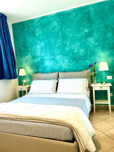a bedroom with a large bed with a blue wall at Cortile Sant'Agostino - Suites & Rooms in Mazara del Vallo