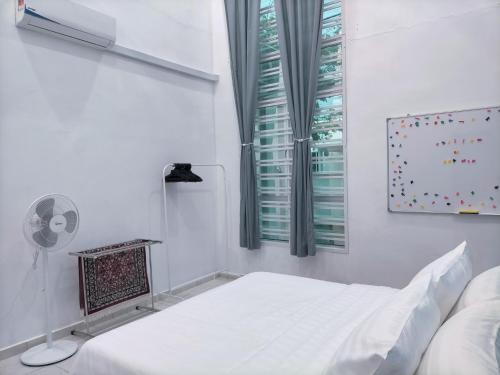 a white room with a bed and a window at Homestay 88A Melaka for 9 pax with Smart TV and Netflix and wifi in Melaka