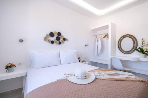 a white bedroom with a bed with a hat on it at Perissa Secret in Perissa