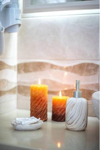 two candles sitting on a counter next to a window at Perissa Secret in Perissa