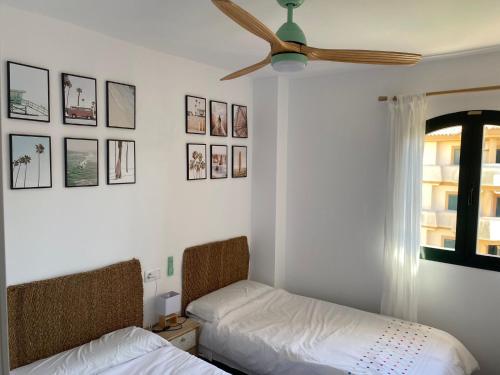 a bedroom with two beds and a ceiling fan at Ático duplex en Zahara de los Atunes in Zahara de los Atunes