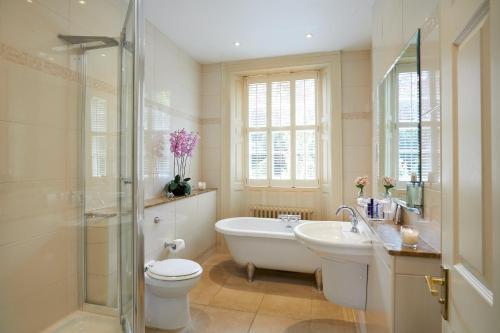 a bathroom with a tub and a toilet and a sink at Ansty Hall in Coventry