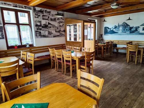 Lišov的住宿－Malostranská restaurace，用餐室配有木桌和椅子