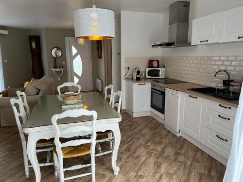 une cuisine avec une table et des chaises dans une pièce dans l'établissement La Villa Marguerite, à Sainte-Marguerite