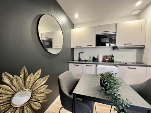 - une cuisine avec une table, des chaises et un miroir dans l'établissement T2 Hyper Centre, à Toulouse