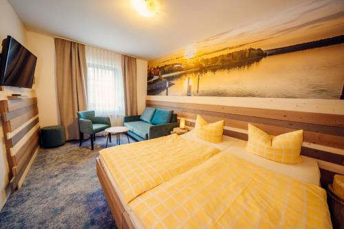 a hotel room with a bed and a chair at Hotel-Pension Hafemann in Senftenberg