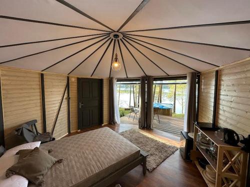 ein Schlafzimmer mit einem großen Bett und einem großen Zelt in der Unterkunft Kaimo Turizmo Sodyba Šniūrai in Mindūnai