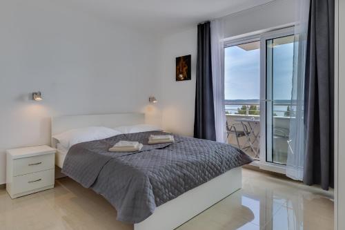 a bedroom with a bed and a large window at Villa Stjepanovic in Tribanj-Krušćica