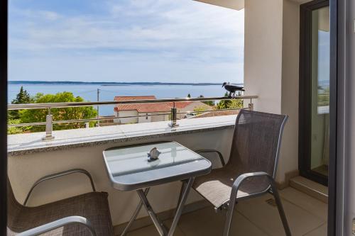 a table and chairs on a balcony with a view at Villa Stjepanovic in Tribanj-Krušćica