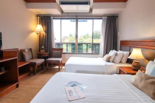 Postel nebo postele na pokoji v ubytování Tohsang Heritage Ubon Ratchathani Hotel