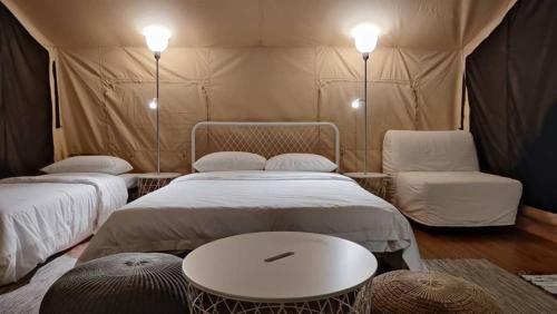 a tent with two beds and a table and a chair at Canopy Villa Sireh Park in Johor Bahru