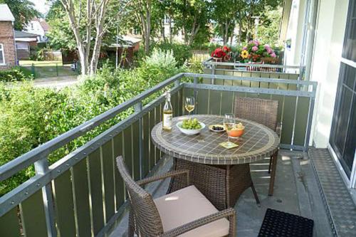 Un patio con una mesa y sillas en un balcón. en Altes Wasserwerk App 14, en Wustrow