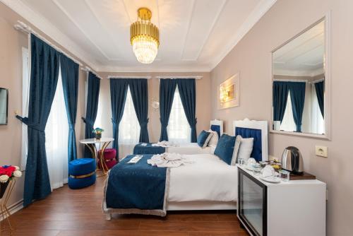 ein Schlafzimmer mit einem großen Bett und blauen Vorhängen in der Unterkunft Begonville Corner in Istanbul