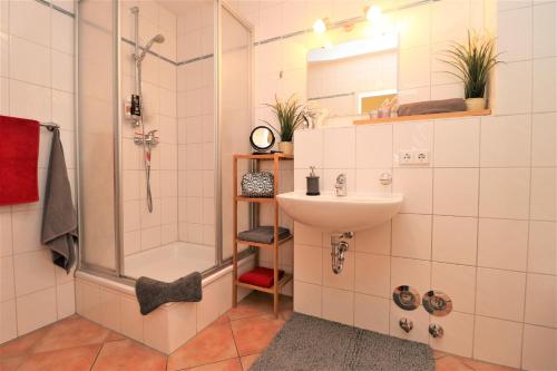 een badkamer met een douche, een wastafel en een douche bij Achtern Hafen App 01 in Wustrow