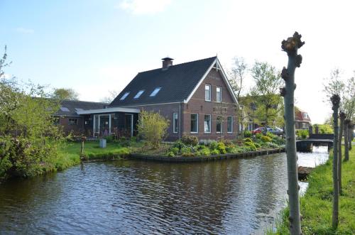 a house on the side of a river at Bed and breakfast Hoeve Spoorzicht in Papekop