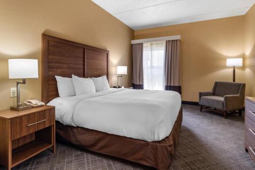 a hotel room with a large bed and a chair at Comfort Inn & Suites at Stone Mountain in Stone Mountain