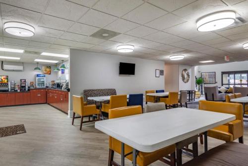 a dining room with tables and chairs and a counter at Comfort Inn & Suites at Stone Mountain in Stone Mountain