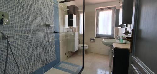 a bathroom with a shower and a toilet and a sink at Maison Marie in Cala Gonone