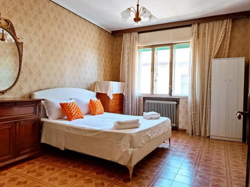Schlafzimmer mit einem Bett, einem Spiegel und einem Fenster in der Unterkunft Locazione Turistica in Tessera