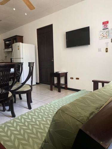 a living room with a television on a wall at Nacazcol - Playas del Coco in Coco